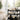 A professional, organized high-end spa trolley system fully stocked with massage oils, waxing supplies, and skin care products in a modern treatment room.