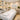 A serene and beautifully organized professional salon treatment room, featuring a comfortable massage bed, clean towels, and neatly arranged spa products on a trolley, ready for a client.