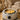 A digital thermometer displaying the accurate temperature of melted wax in a professional wax warmer, with wooden spatulas nearby, symbolizing the key to perfect wax consistency and burn prevention.
