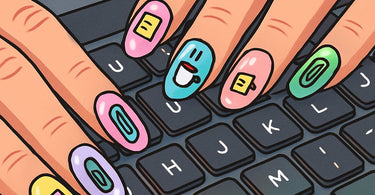 A woman's hands with a chic, short manicure typing on a laptop keyboard, showcasing office-appropriate nail art.