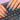 A woman's hands with a chic, short manicure typing on a laptop keyboard, showcasing office-appropriate nail art.