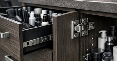 A modern, sturdy white salon cabinet with a stone countertop, holding various professional beauty products and towels, illustrating the heavy-duty reality of salon cabinetry.