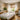 Elegant spa treatment room featuring a professional massage table with soft, natural light filtering through stylish white window blinds, creating a serene and relaxing ambiance for clients.