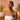 A smiling woman with glowing skin leaving a spa, carrying a branded retail bag, embodying post-treatment confidence
