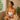 A thoughtful aesthetician in a spa setting gently assesses a client's skin, highlighting professional care and sun damage evaluation.