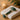 Close-up of a professional esthetician using a cold jade roller on a client's cheek to soothe redness and inflammation after a facial extraction.
