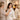 A spa professional smiling warmly as a client looks joyfully at her own reflection in a hand mirror after a treatment