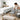 A collection of cleaning tools like a spray bottle and brush arranged neatly on a clean, beige upholstered massage table in a spa, representing the importance of professional furniture maintenance.