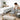 A collection of cleaning tools like a spray bottle and brush arranged neatly on a clean, beige upholstered massage table in a spa, representing the importance of professional furniture maintenance.