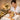 Close-up of a professional esthetician applying delicate gold leaf sheets during a luxurious anti-aging facial treatment in a spa setting