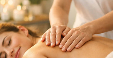 Close up of professional hands with confident, grounding hand placement on a client's back during a spa treatment, emphasizing the psychology of touch and proper technique.