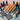 Close-up of a nail art stamping session showing vibrant designs on a stamper and finished nails