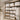 A beautifully organized spa linen closet with neatly stacked white towels on shelves, baskets of supplies, and spa products, representing efficiency and order.