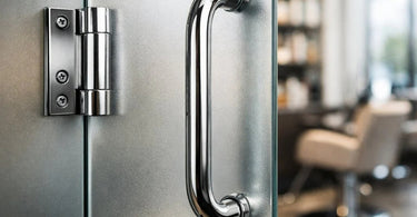 Close-up of elegant, modern black metal door handles and hinges on a white door, highlighting the importance of stylish and functional hardware in a salon or spa setting.