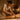 A waxing professional demonstrating proper ergonomic posture and body mechanics while performing a waxing service in a spa