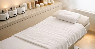 A serene and focused esthetician performs a precise Brazilian wax service in a calm, clean spa treatment room.