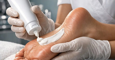 Close-up of a professional applying urea cream to a client's dry heel during a spa pedicure treatment