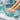 Close-up of a woman's feet receiving a professional pedicure treatment with a disinfectant soak in a modern spa setting