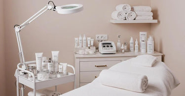 Spa treatment room essentials laid out neatly on a table including towels, waxing supplies, and skincare products