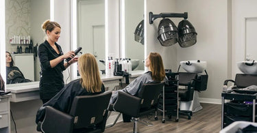 Modern salon equipment setup featuring facial steamers, massage tables, and waxing supplies