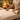 A close-up image of a soft, white biodegradable massage table paper roll being neatly torn along a perforation, laying on a clean massage table.