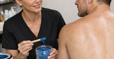 Professional esthetician applying hard wax to a male client's back for efficient large surface area hair removal