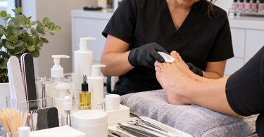 Professional waterless pedicure setup with nail care tools, foot treatment supplies, moisturizing products, and salon equipment for a soakless pedicure service