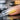 A close-up image of a professional nail technician applying a clear acrylic overlay, highlighting the importance of technique and quality supplies to prevent yellowing.