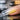 A close-up image of a professional nail technician applying a clear acrylic overlay, highlighting the importance of technique and quality supplies to prevent yellowing.
