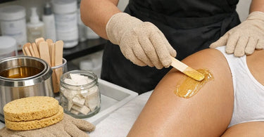 Eco-friendly biodegradable sponges and protective gloves for professional spa and salon use displayed on a bamboo surface