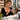 Client using a smartphone with freshly completed nail enhancements, illustrating manicure aftercare, nail salon habits, and protection of professional nail designs