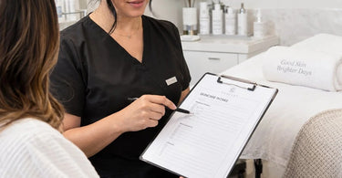 A professional clipboard with a client intake form resting on a spa reception desk, representing the importance of paper consultation in beauty and wellness services.