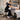 Massage Therapist using a large full-round bolster to support a client's knees, illustrating proper body mechanics and client comfort on a massage table.
