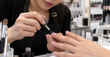 Professional glossy manicure highlighting a smooth nail finish and the importance of keeping dust and lint away from top coat
