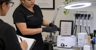 Spa team gathered around a portable massage table during a group training session, with supplies from Pure Spa Direct