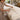 Professional heated massage table in a spa treatment room with layered white linens and a warming pad illustrating uneven warmth and hot spot prevention