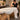 Professional massage table with a blanket sliding unevenly off one side, illustrating common spa bedding and treatment room draping problems