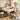 A professional massage therapist sitting comfortably on an adjustable stool next to a massage table, highlighting the importance of ergonomic seating in a spa setting.