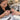 Professional nail technician checking a sculpting nail form under a client finger for straight alignment before applying acrylic or gel