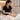 A professional esthetician applying a pre-cut wax strip to a client's leg, demonstrating efficient service timing and technique.