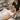 Spa owner confidently raising price sign with happy premium client receiving luxury facial treatment using professional equipment