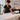 A close-up of a hand pressing into a plush, white massage table sheet, highlighting the texture and comfort for a superior client experience.
