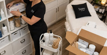 A collection of pure spa direct wholesale boxes and supplies being organized by a professional staff member at a spa or salon, emphasizing the importance of knowing where new deliveries belong.