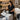 Smiling spa professional holding neatly organized supplies representing a well-stocked treatment room