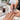 Professional nail technician applying clear top coat over colored nail polish, demonstrating how brush pressure and application technique can cause nail color to drag or smear
