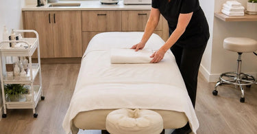 A professional spa provider working comfortably around a treatment table with ample clearance, showcasing ergonomic practice.