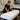 A professional waxing bed in a modern salon setting, showcasing multiple protective layers including a disposable paper cover and a fresh white towel, emphasizing hygiene and client comfort.