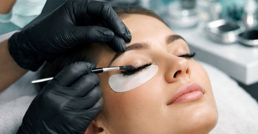 Close-up of a professional lash artist applying a gentle PPD-free lash tint to a client with sensitive eyes in a serene spa setting