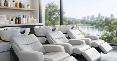 Luxurious modern salon shampoo area with a stunning view of a lush green garden through large windows, featuring sleek black shampoo bowls and comfortable chairs.