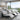 Luxurious modern salon shampoo area with a stunning view of a lush green garden through large windows, featuring sleek black shampoo bowls and comfortable chairs.